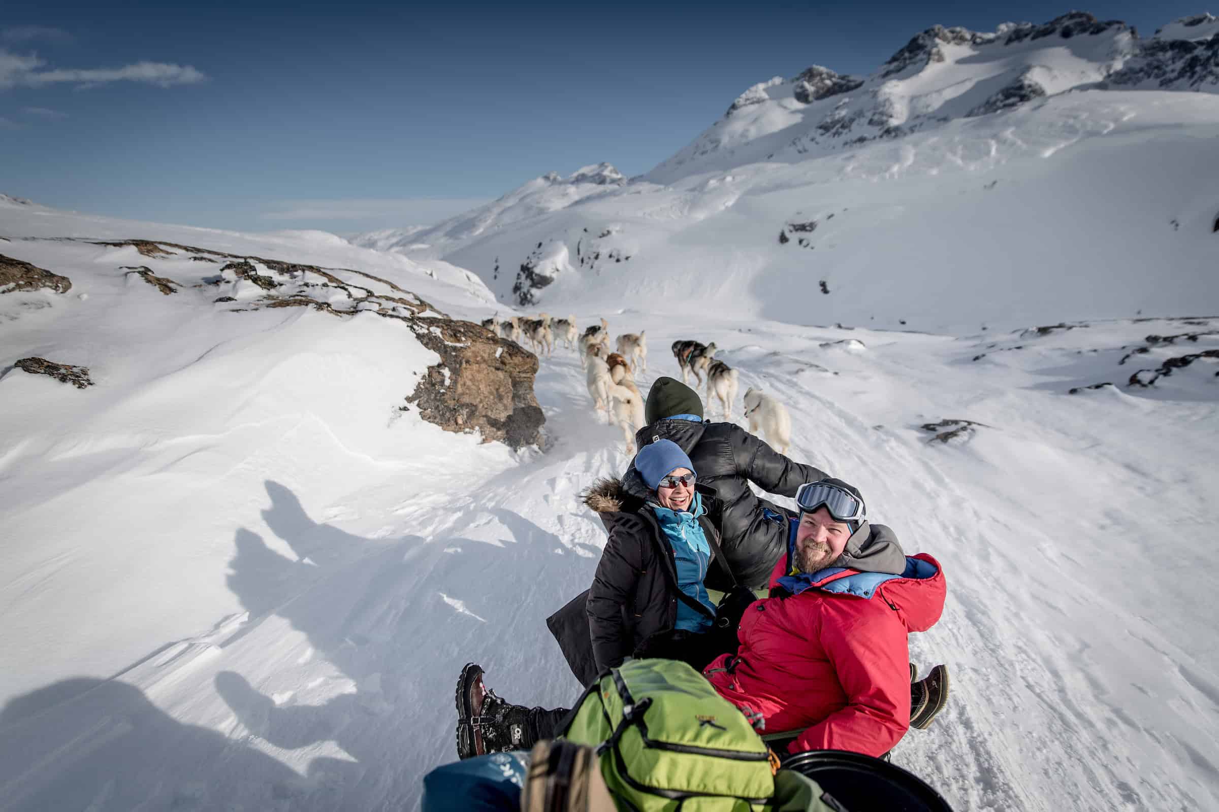 A dog sled speeding around a corner on the trail near Tasiilaq in East Greenland. Photo by Mads Pihl - Visit Greenland
