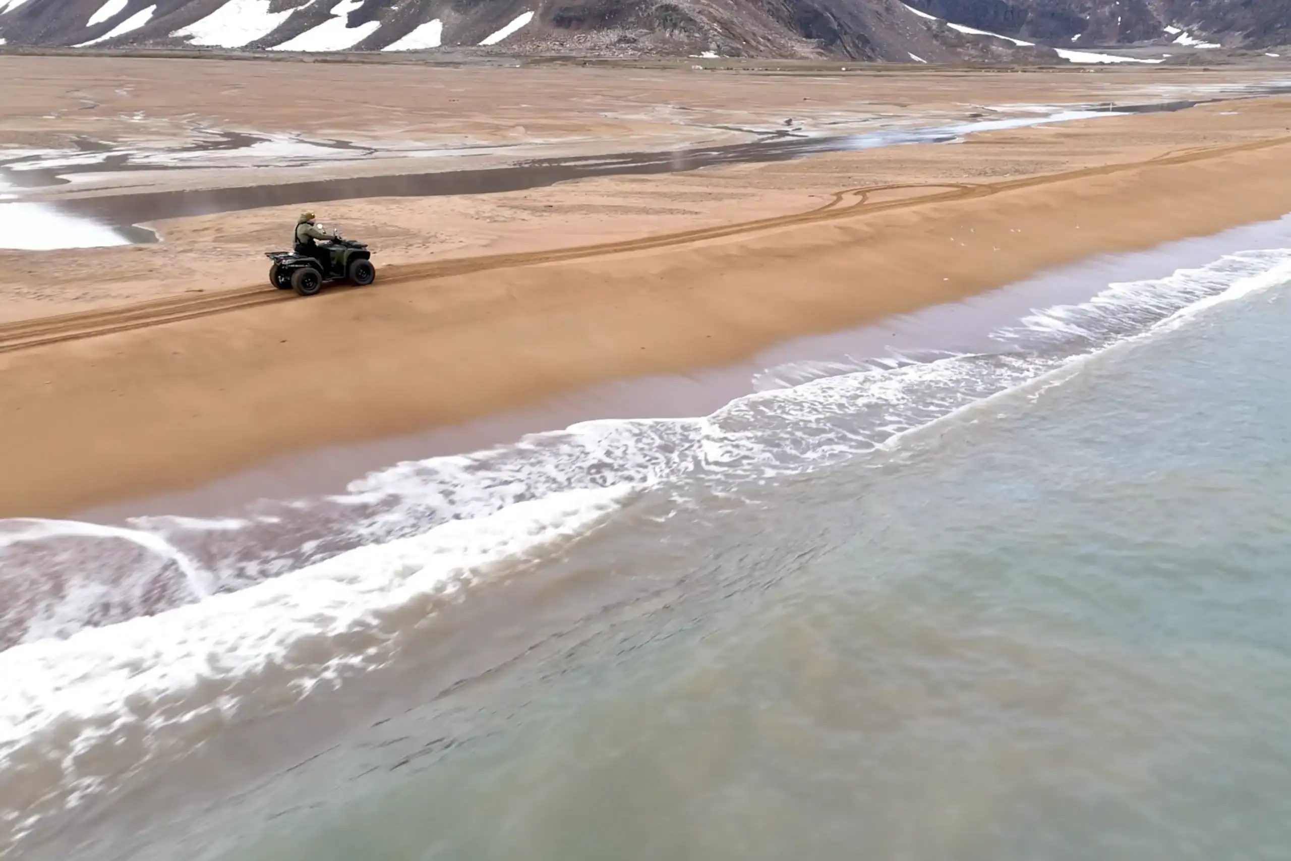 ATV driving on the sandy beach at Walrus bay, close to Ittoqqortoormiit.
