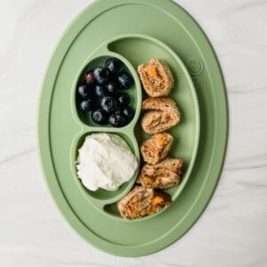 This is a photo of a baby led weaning meal with a tahini chia jam pinwheels, yogurt and blueberries