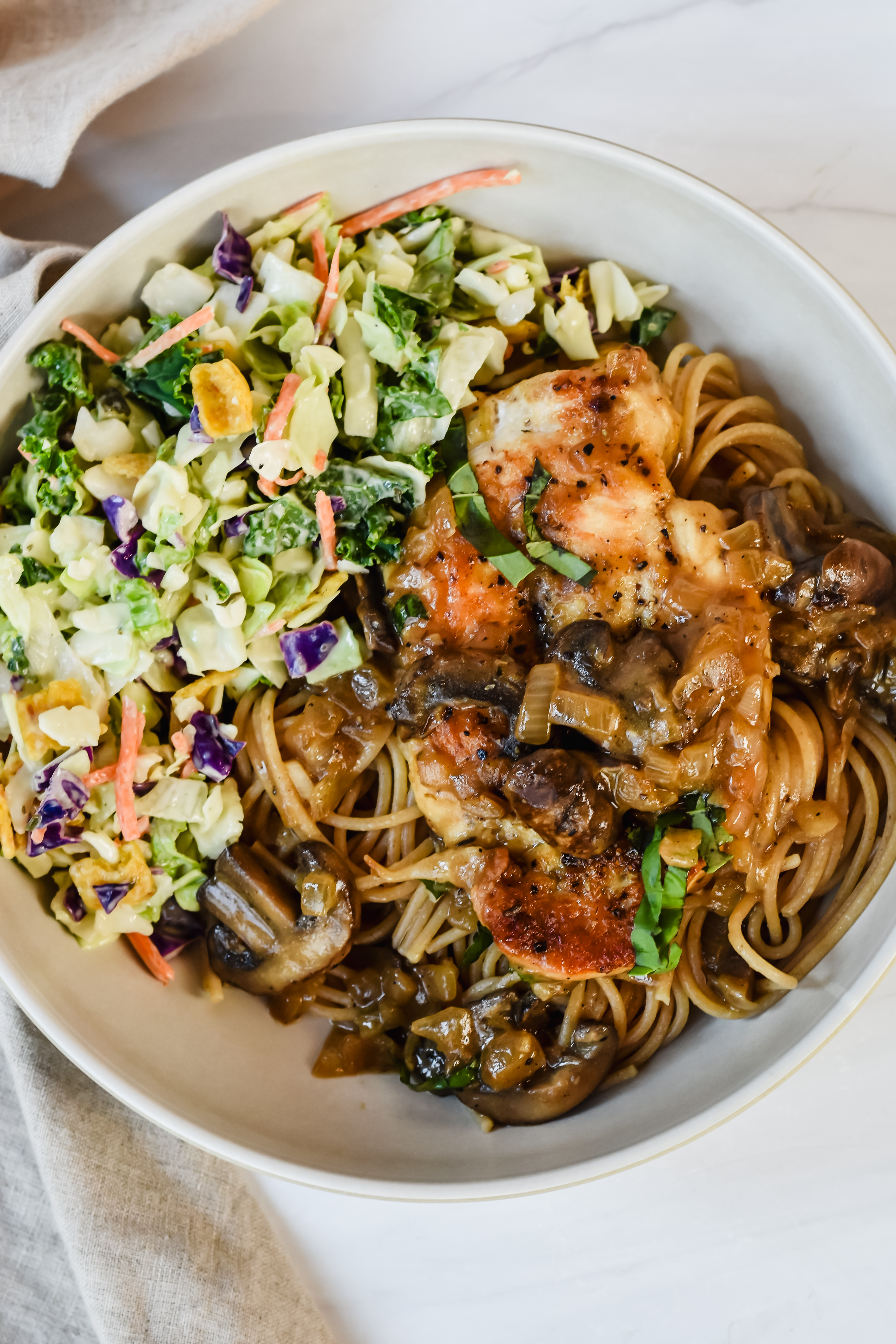 This is a top view of my chicken marsala recipe without wine served on top of whole wheat pasta and with a side salad for additional fiber and nutrients.