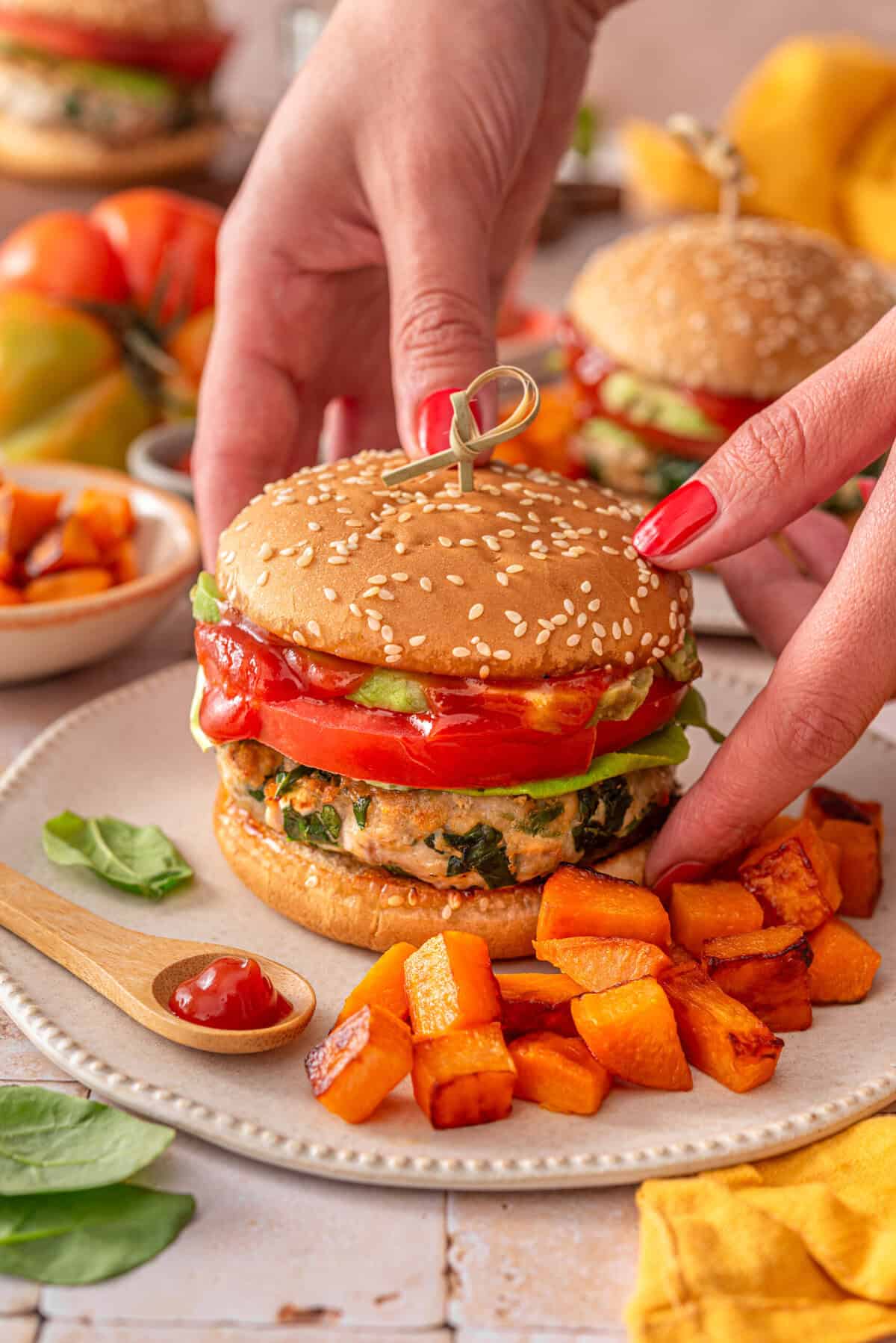 this is a side view of me putting down my healthy chicken feta spinach burgers on a plate. 