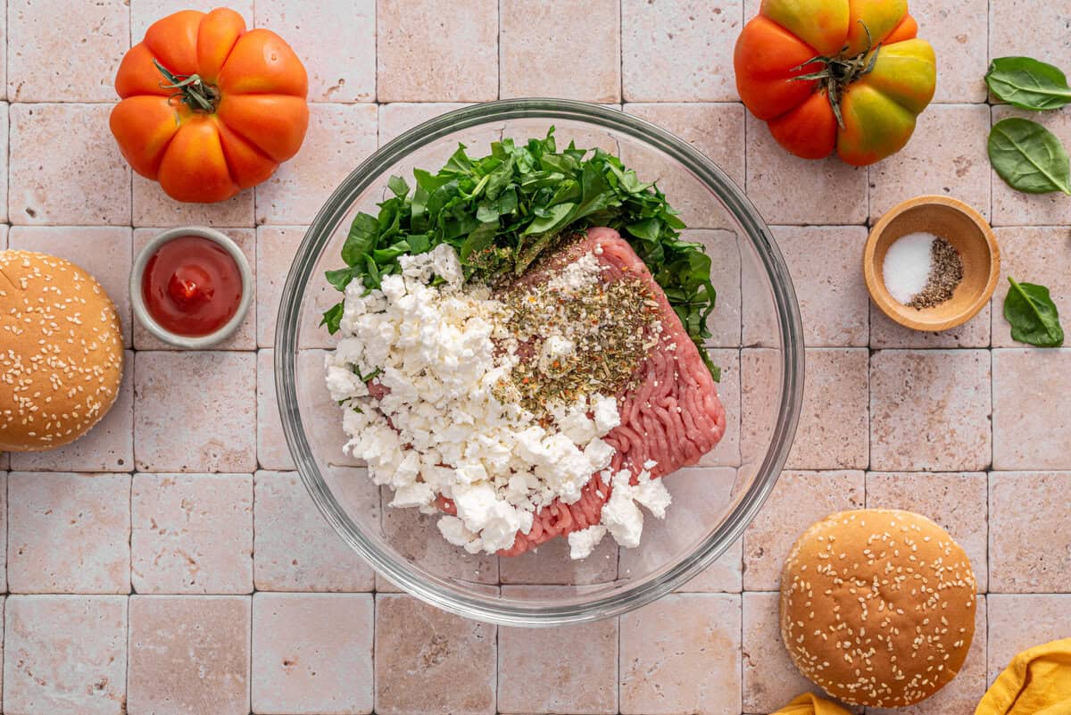 this shows me mixing the ground chicken or turkey with the feta, spinach and spices in a bowl 