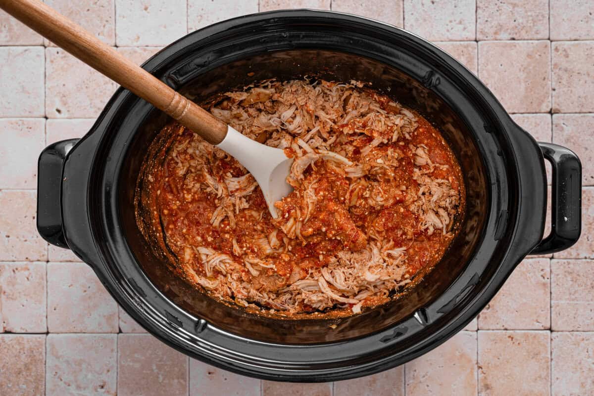 this shows me mixing everything together in the crockpot after shredding the chicken 