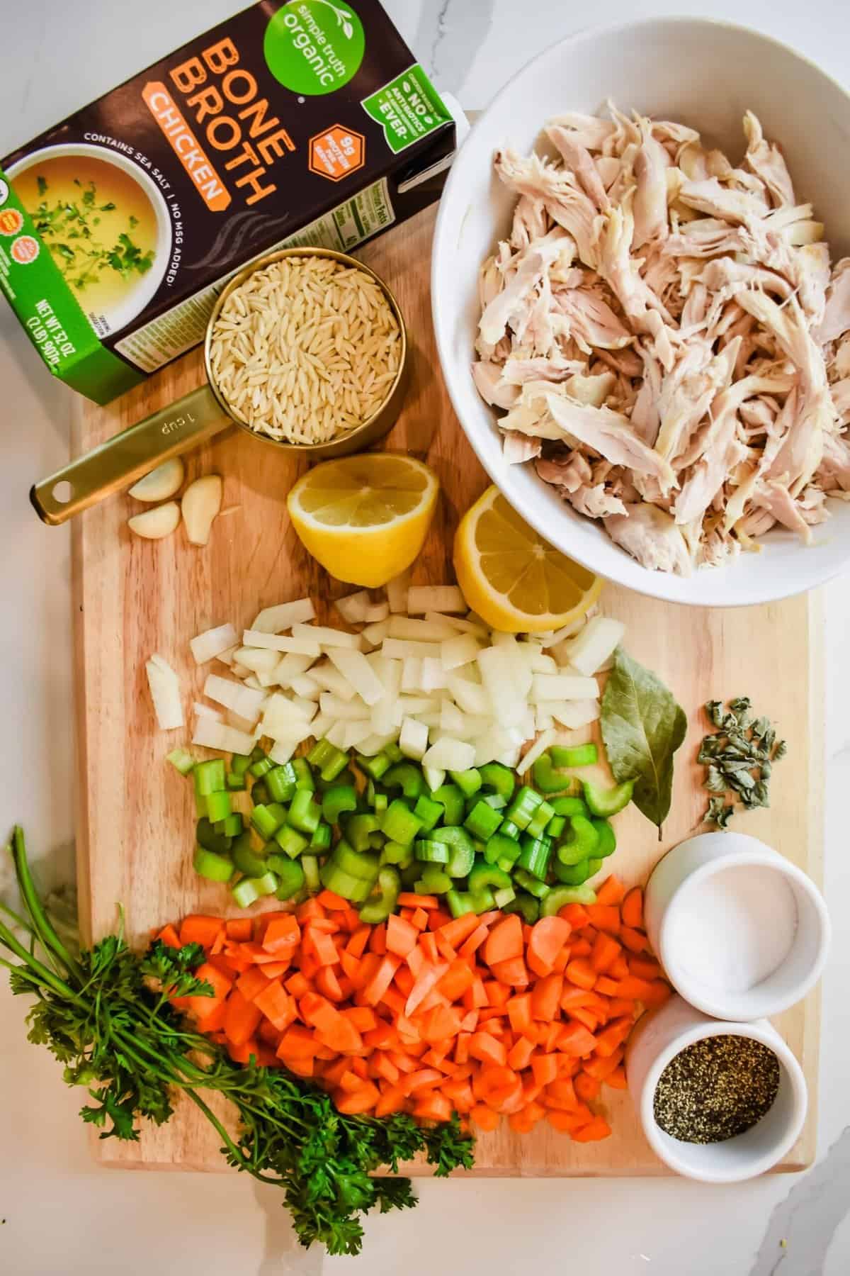 This is a top view of all the ingredients used within this greek lemon orzo soup on a cutting board.  