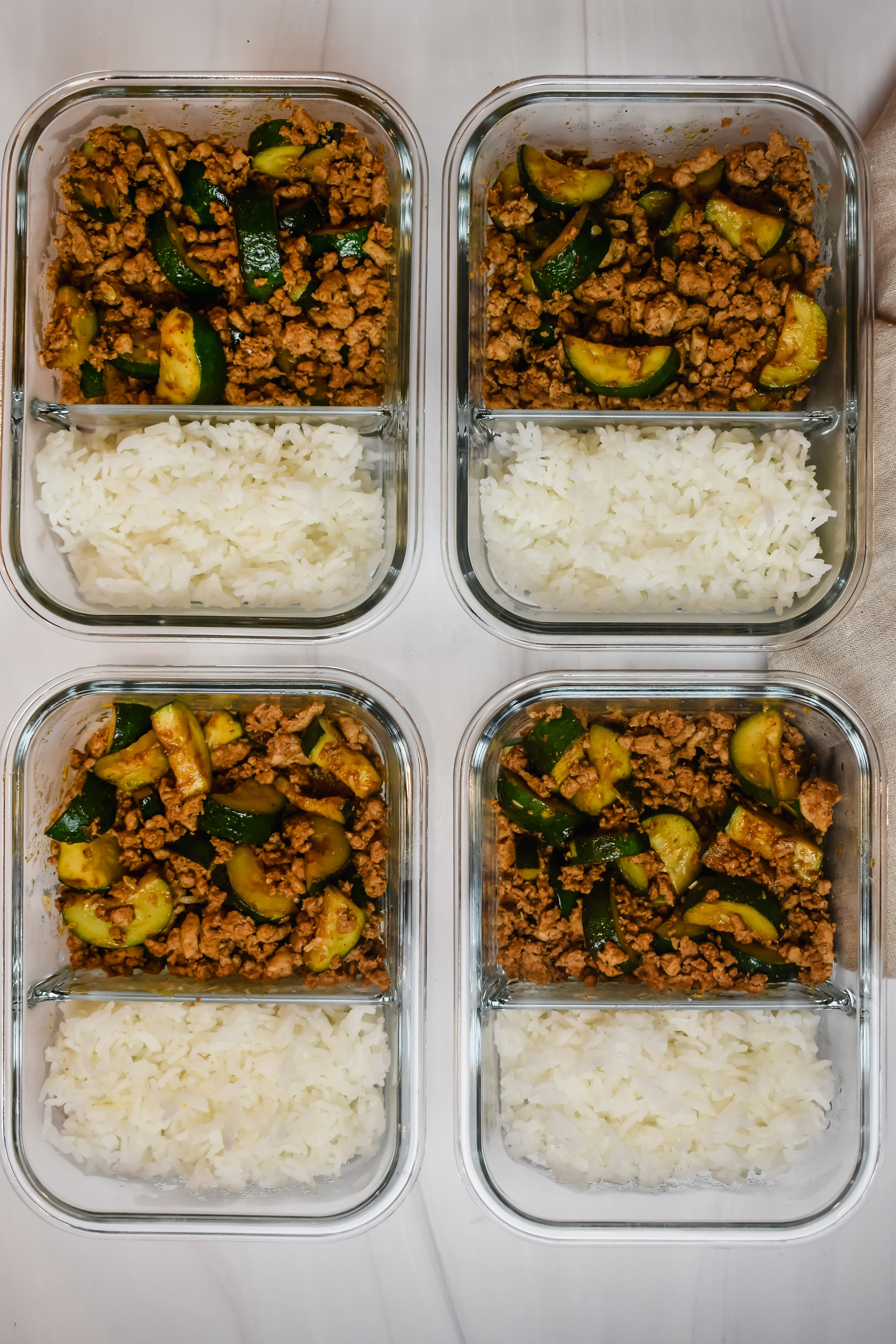 This is a top view photo of 4 containers that have my ground turkey and zucchini meal prep lunch or dinner. 