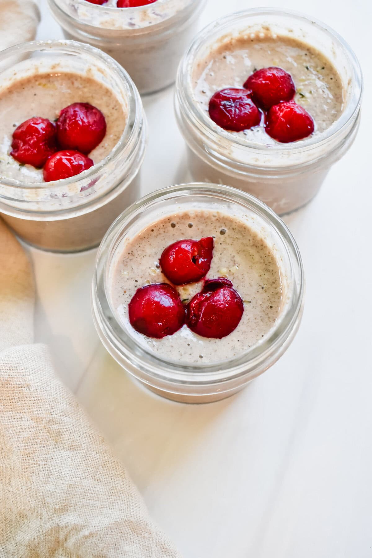 this is a top view close up of my cherry blended oatmeal recipe in 4 small jars for my baby