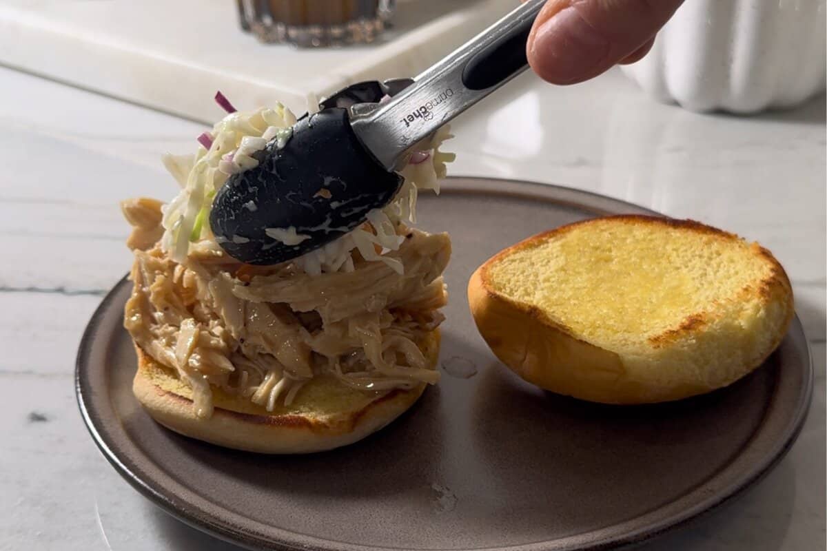 this shows me assembling the sandwich and adding the slaw. 