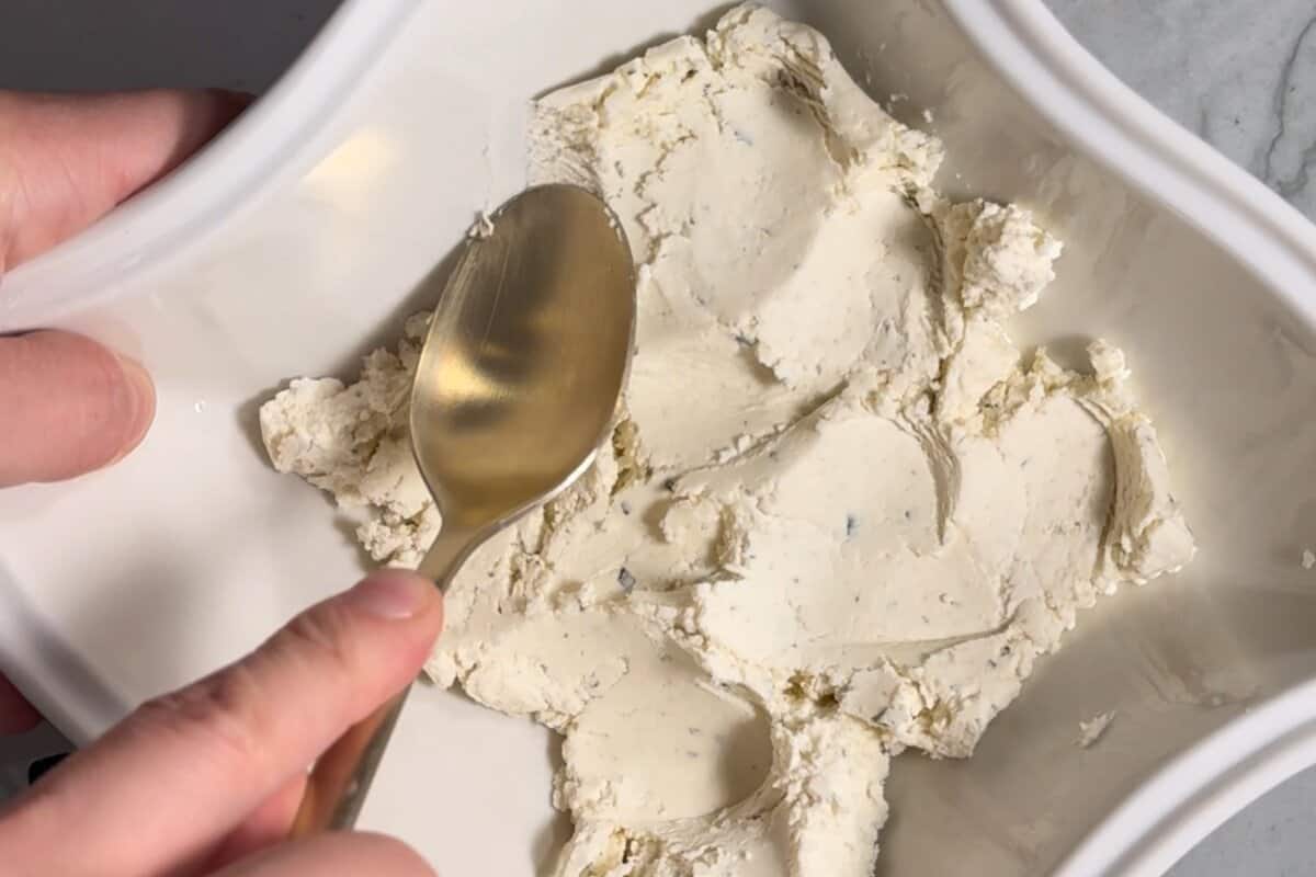this shows me spreading the boursin cheese 