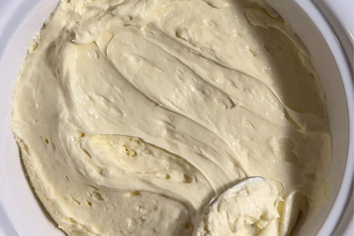 this shows the no bake cheesecake dip being evenly spread into a serving dish 