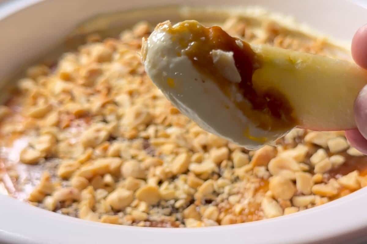 this shows me dipping the apple into the apple caramel cheesecake dip 