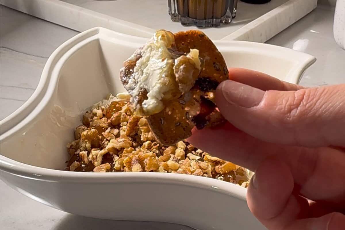 this shows me scooping a bite with a cracker 