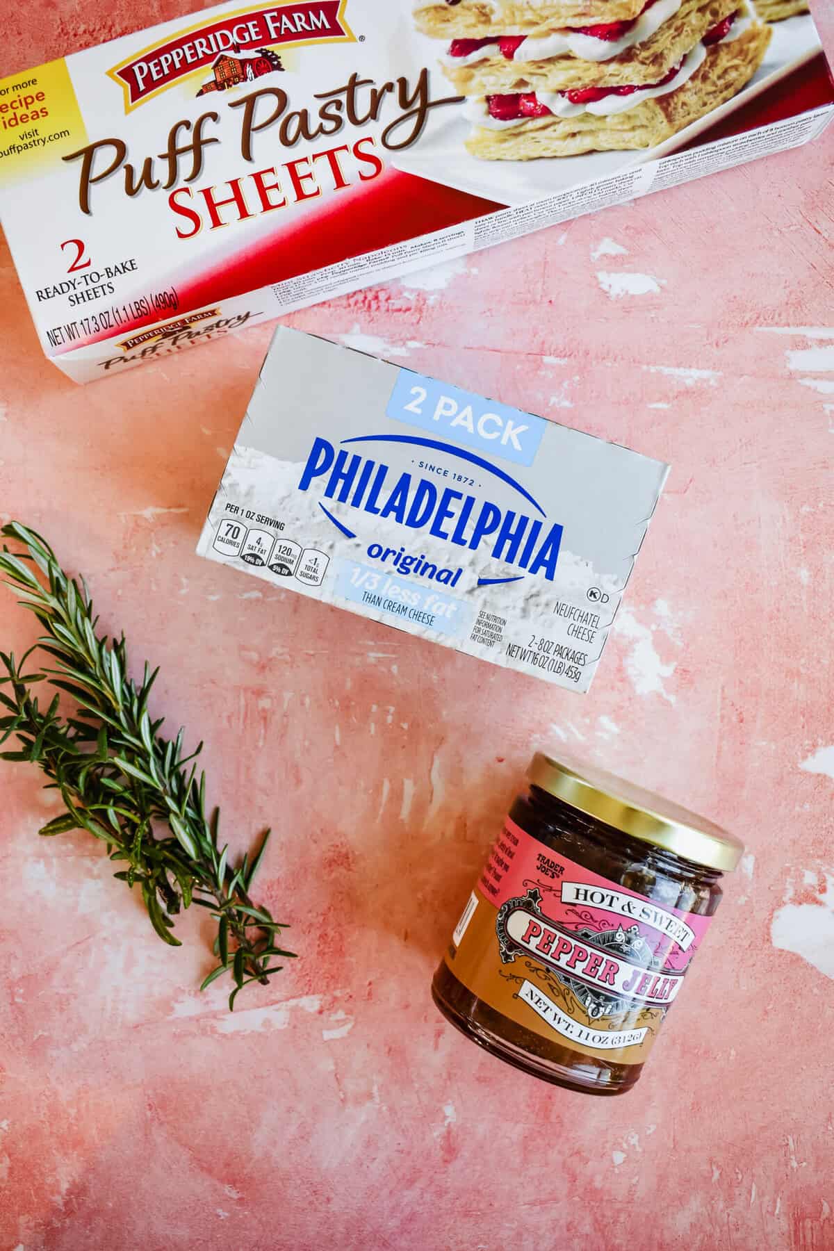 this shows the ingredients you need to make this easy recipe. Low fat cream cheese, puff pastry, hot pepper jelly and rosemary. 