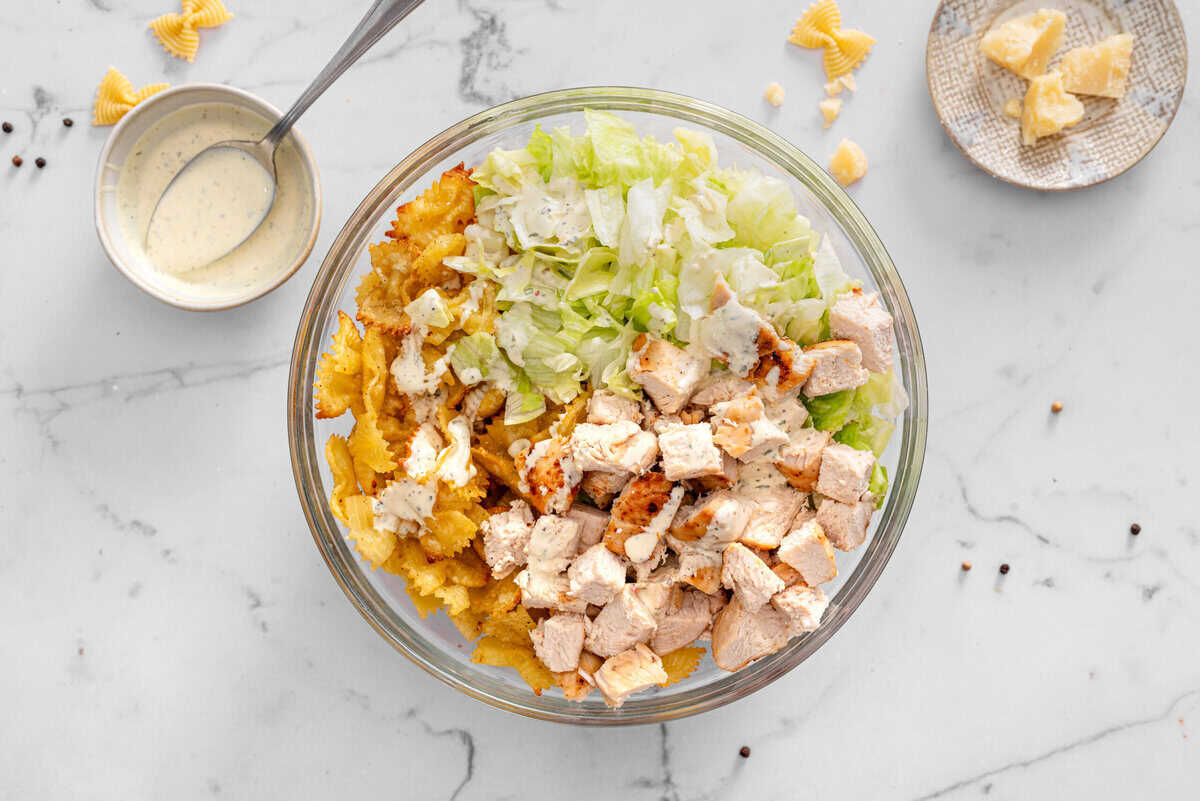 this shows the chicken , lettuce and pasta in a bowl