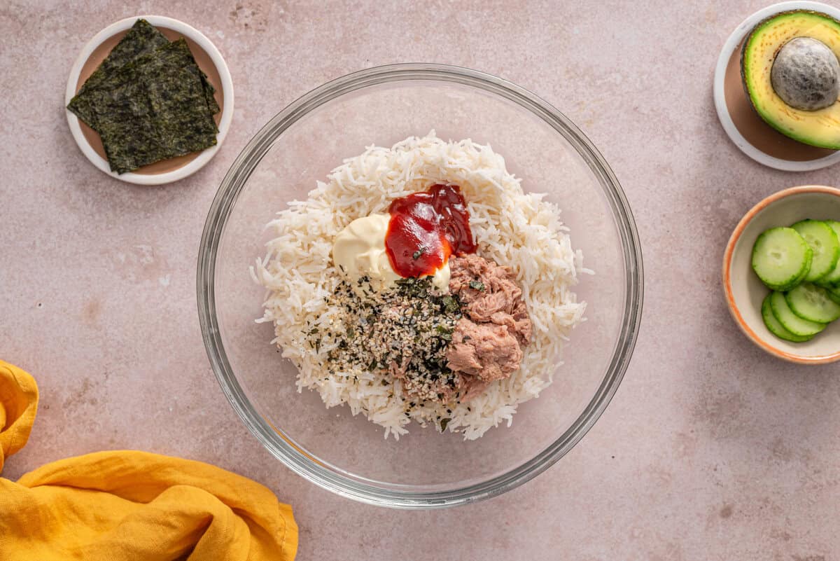 top view of the rice, tuna, mayo, sriracha and seasoning in a bowl 