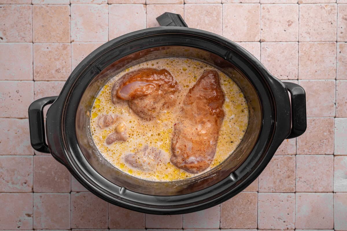Overhead shot of ingredients in slow cooker with curry sauce.