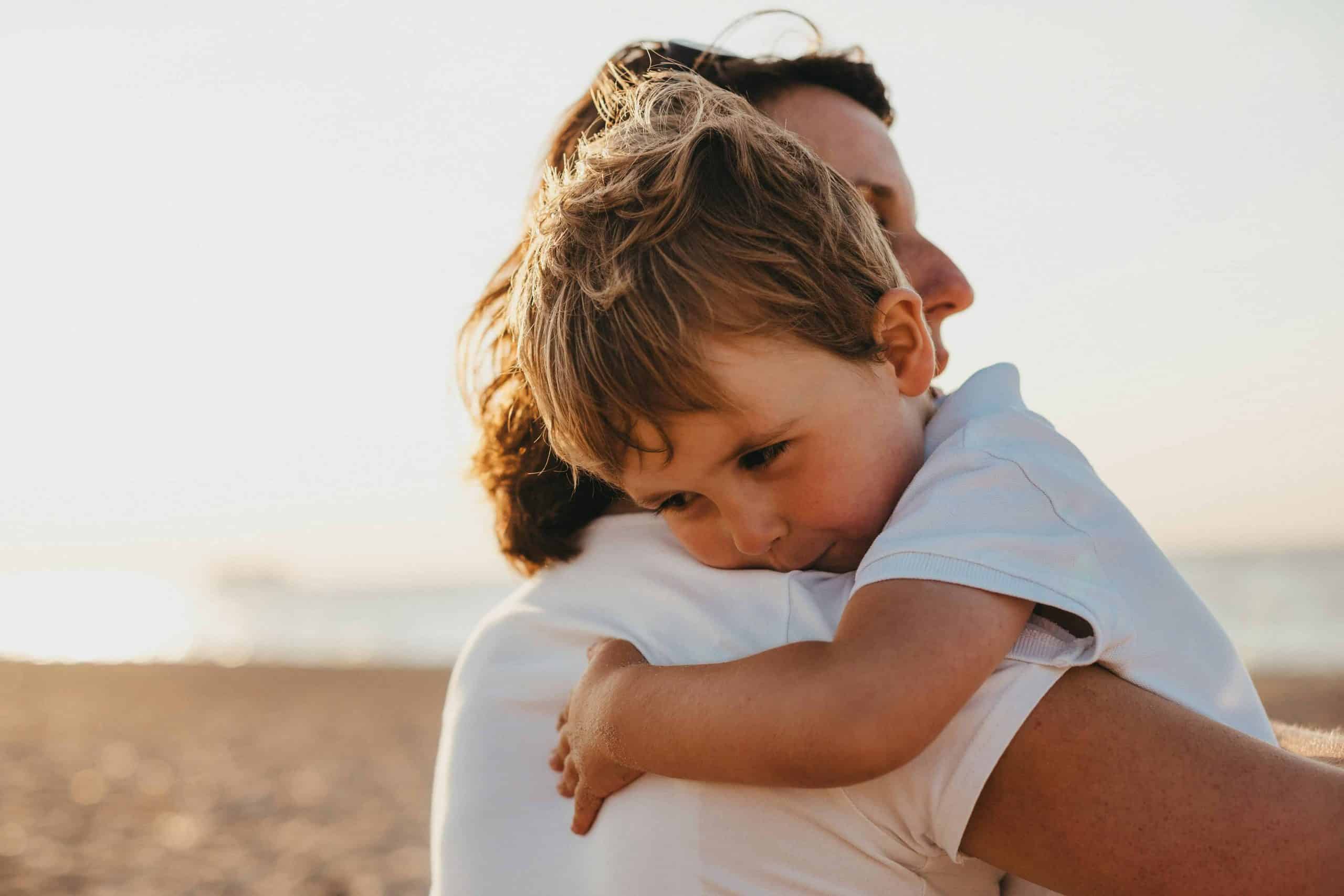 Family hugging on the beach at Edgewater Inn, Charlevoix, Michigan.