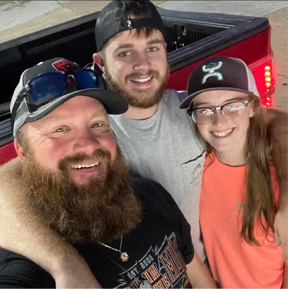 Image of Dustin, owner of Elite Dumpster Services, smiling happily with his son and daughter.