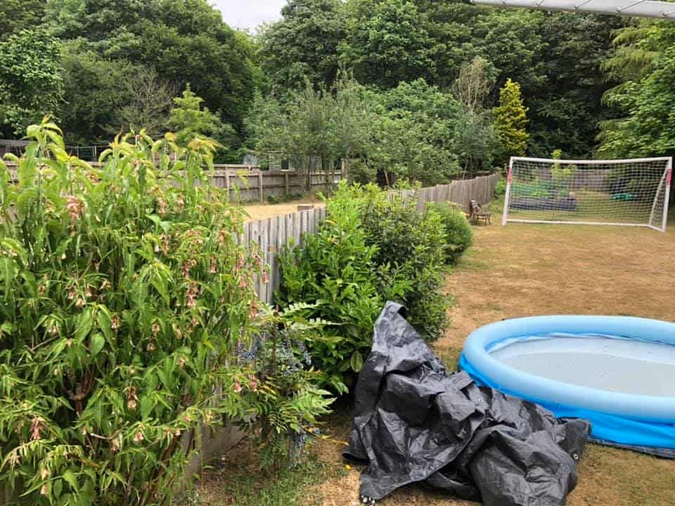 Garden with fencing, gravel boards, and a small inflatable pool.