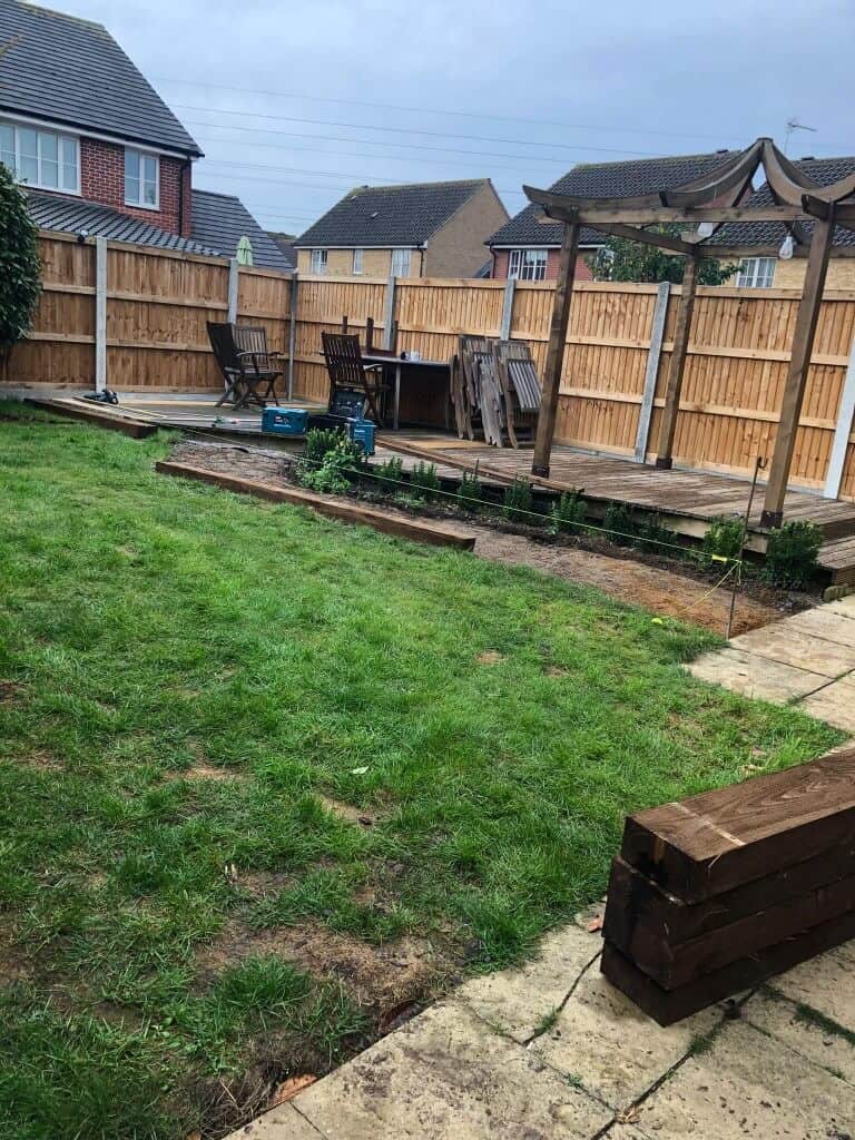 New wooden garden fence with patio and outdoor furniture.