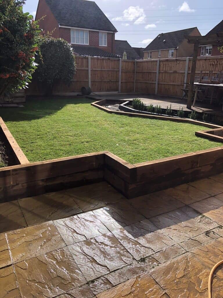 Beautiful garden with new fencing, lawn, and flower bed by EM Fencing and Garden Services.
