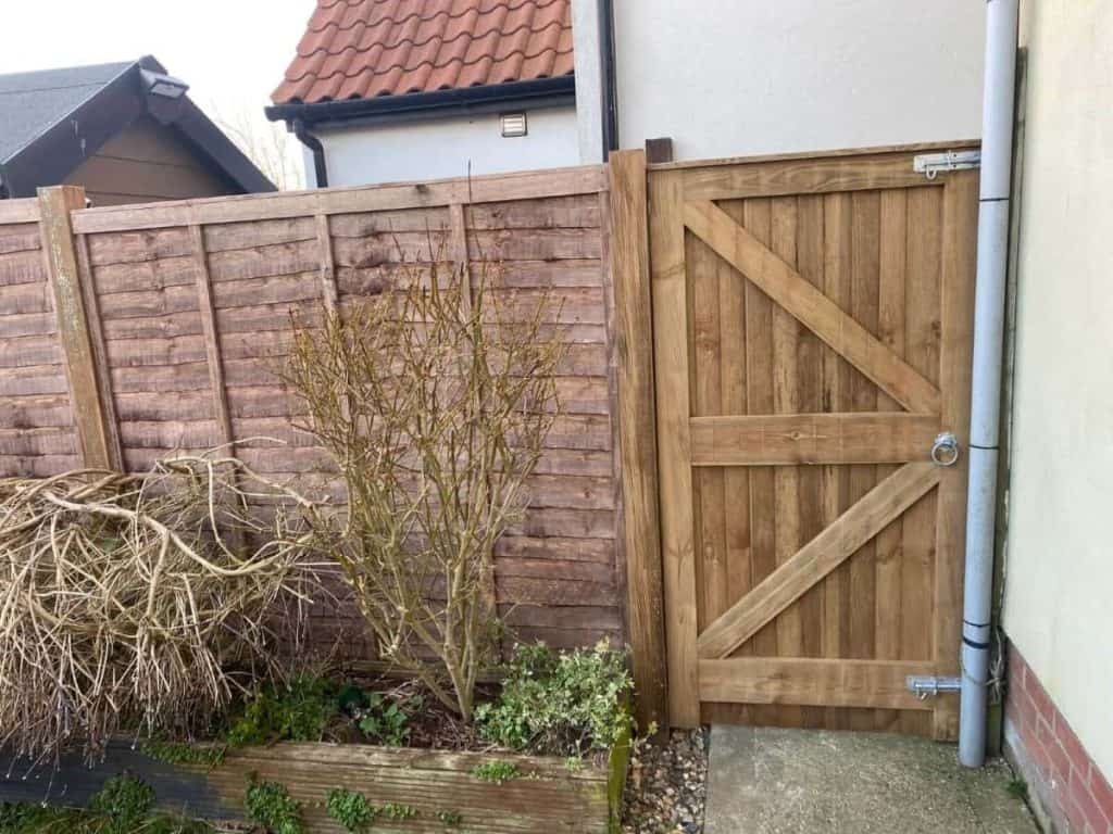 New wooden garden gate with fencing for privacy and security.