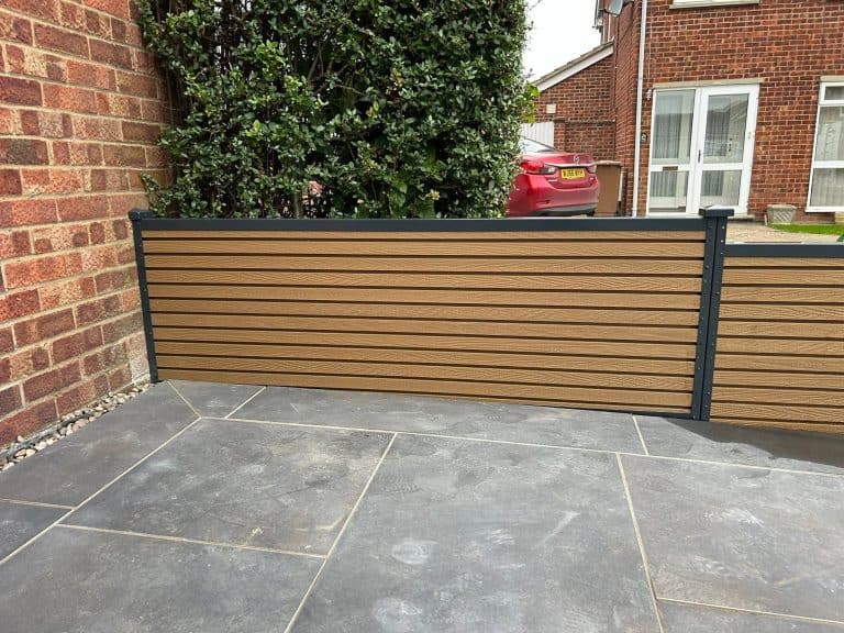 Stylish horizontal wooden garden fence with black frame in residential yard.