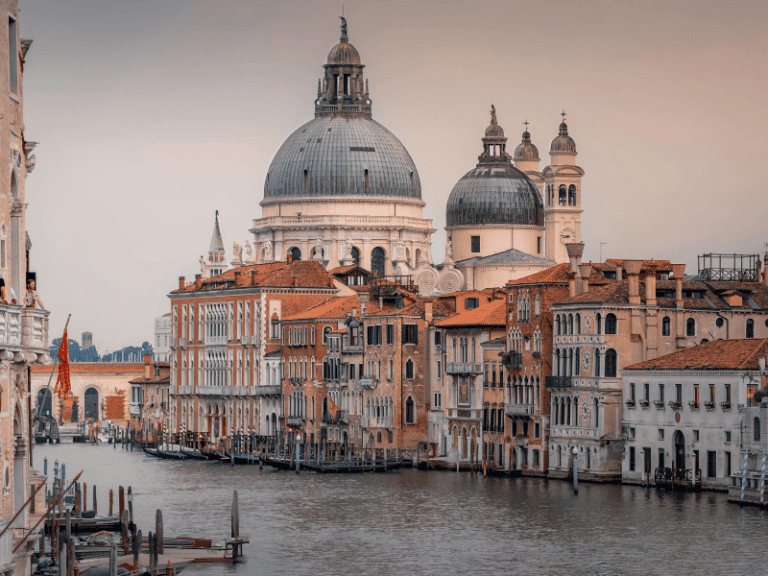 Venice canal with historic buildings and the Basilica di Santa Maria della Salute in the background during winter.