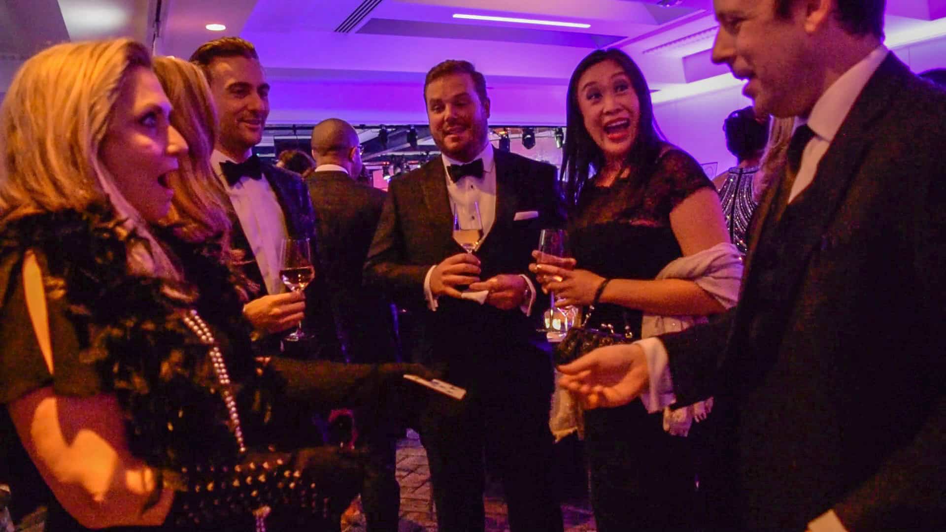 A group of people at a party talking and laughing after seeing magician and mentalist Eric Lerner performing a miracle