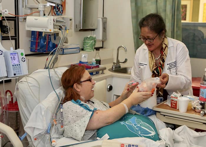 Margarita Camacho hands Lisa Salberg her heart.