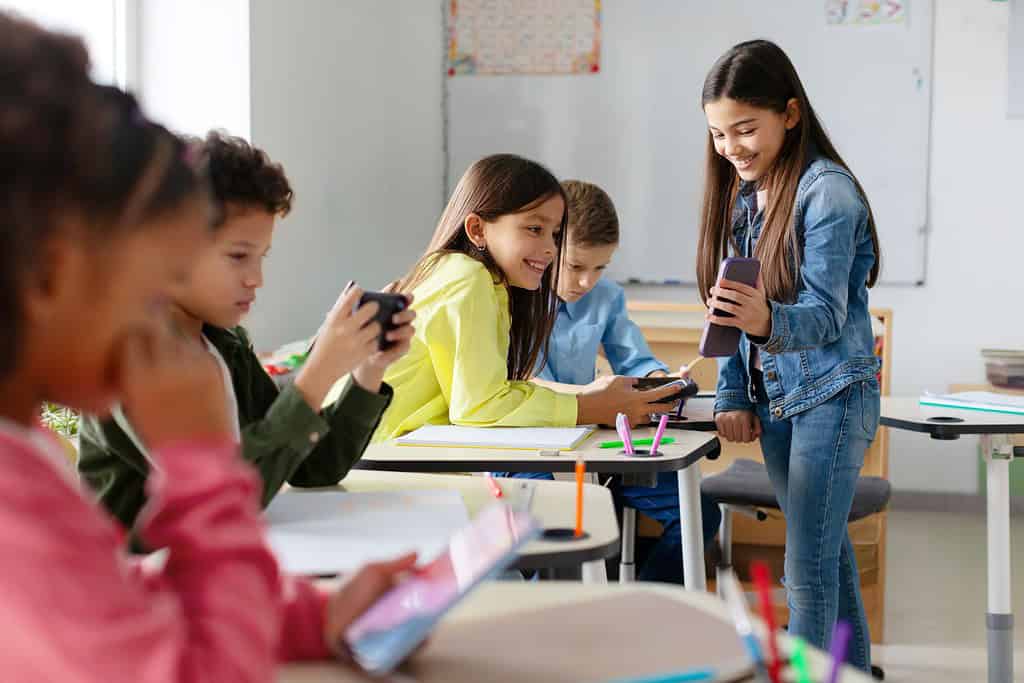 Cellphones in Schools: Unveiling the Pros and Cons 2 a group of children in a classroom