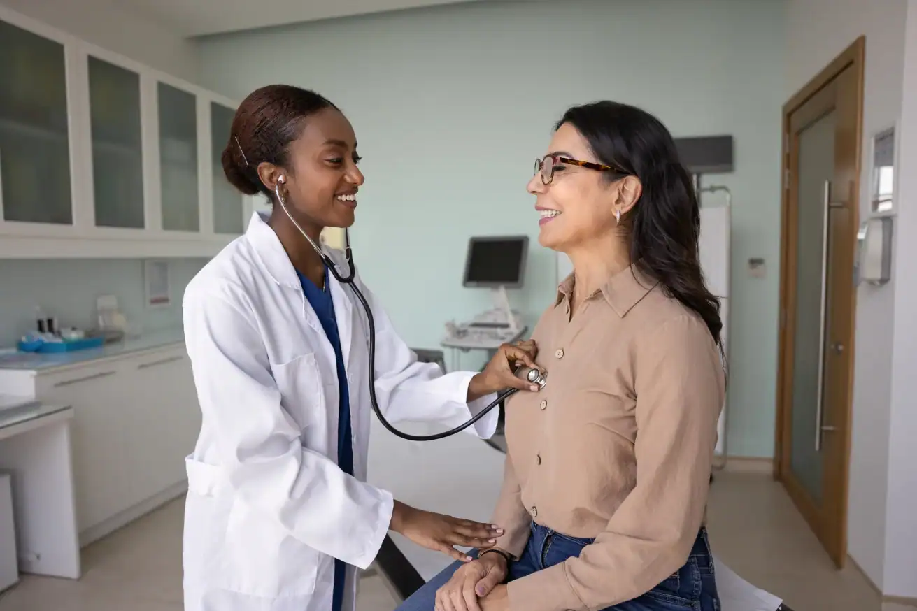 young doctor performing auscultation for a woman participating in cardiovascular disease clinical trials