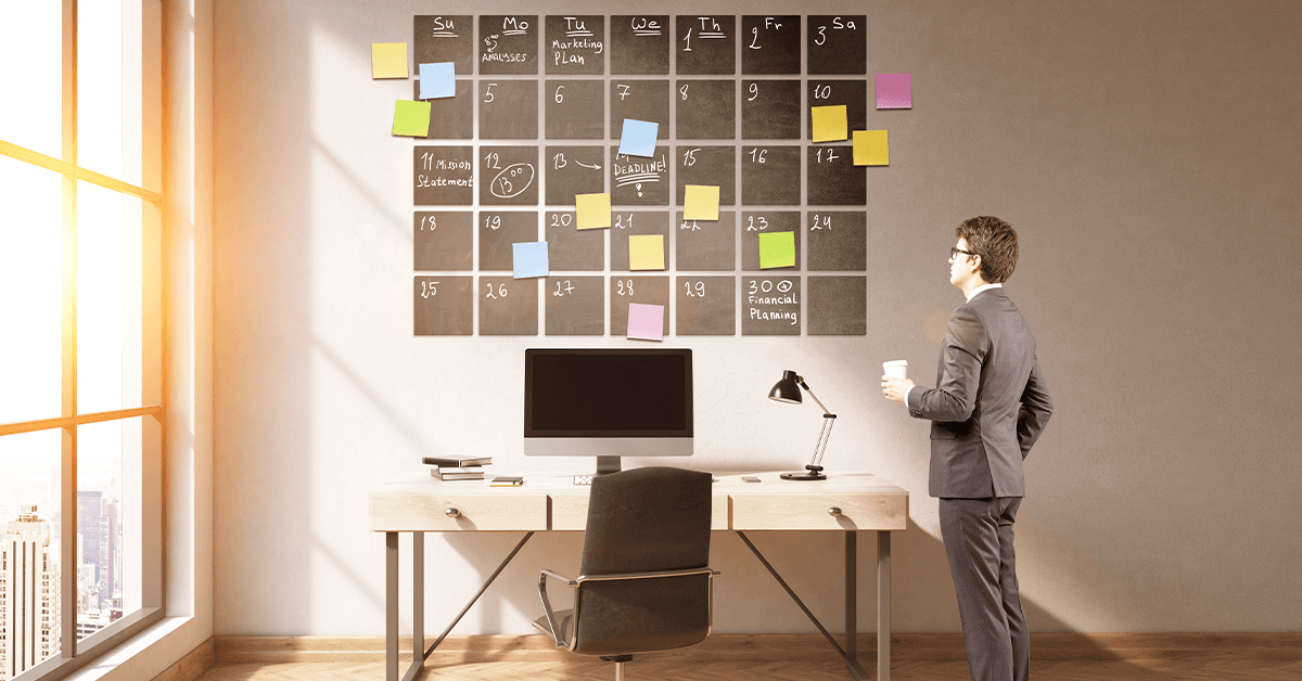 A businessman looking at a 12-month calendar or planning board outlining the steps to prepare a business for sale.