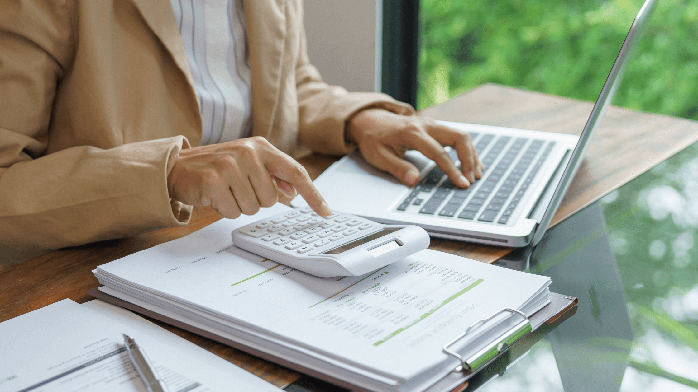 A small business owner calculating figures on a calculator with financial documents, realizing business value goes beyond the P&L.
