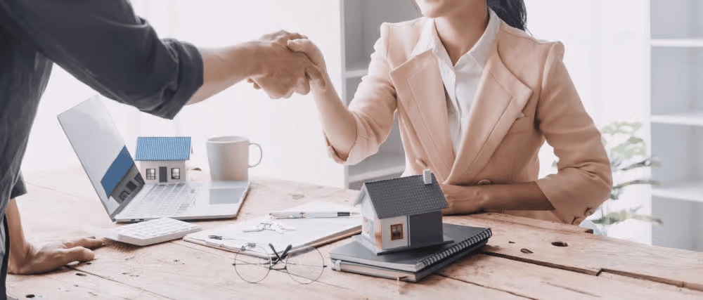 Faith Harmer shaking hands during a real estate consultation.