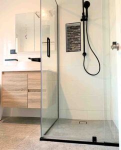 Contemporary walk-in shower with glass enclosure, black showerhead, and sleek design in Ashton Rise.
