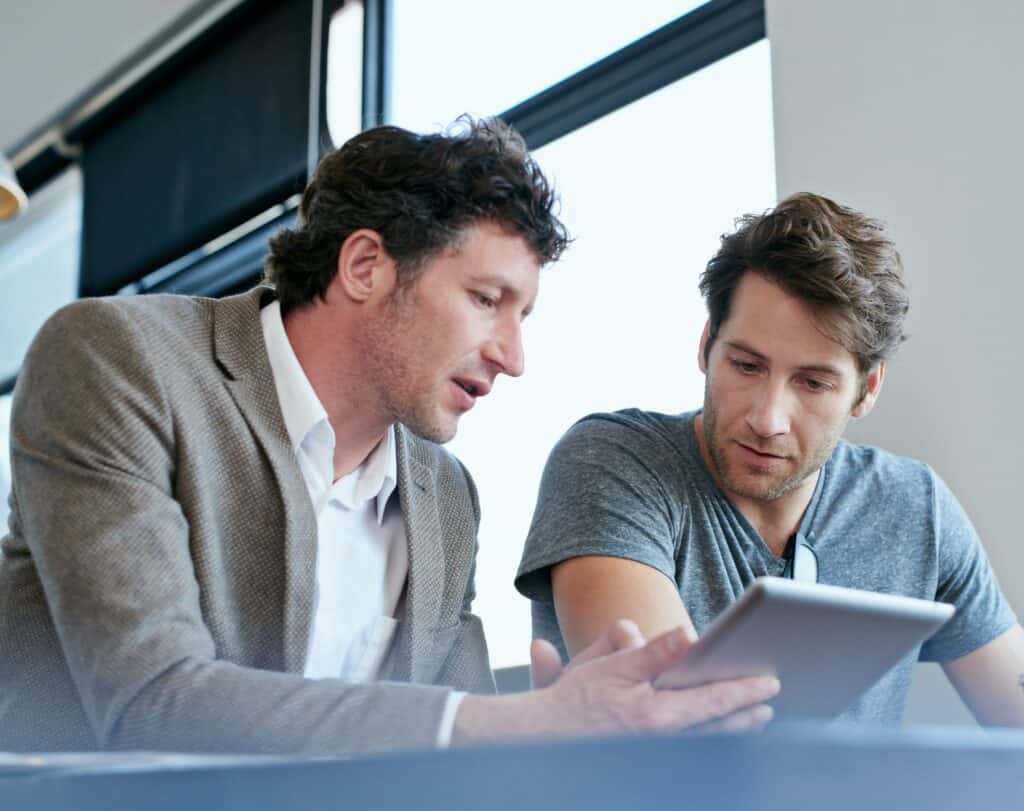 AI in CX growth programs: colleague pointing out an upstream issue on a tablet before it reaches customers