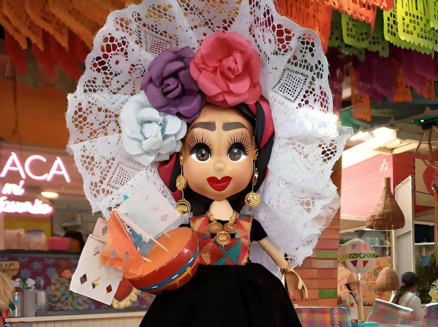Catrina de papel maché con flores y accesorios, muestra la tradición mexicana del Día de Muertos.