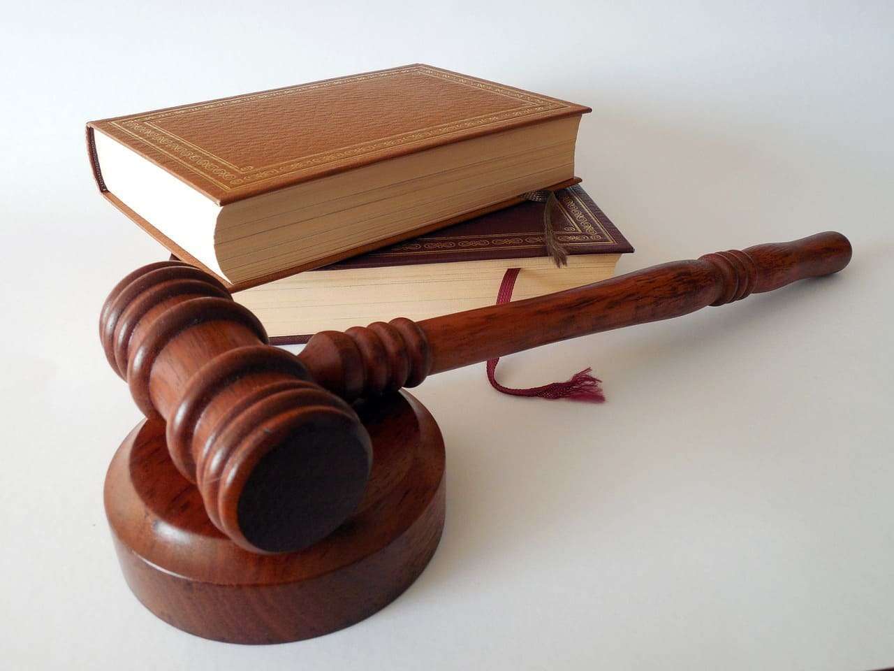 Libro y mazo de juez de madera, símbolo de la justicia y la filosofía del derecho.