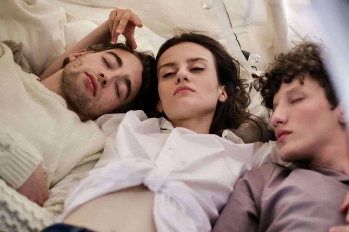 Disfruta del concepto de amistad y cercanía en una escena íntima con amigos descansando juntos en la cama.