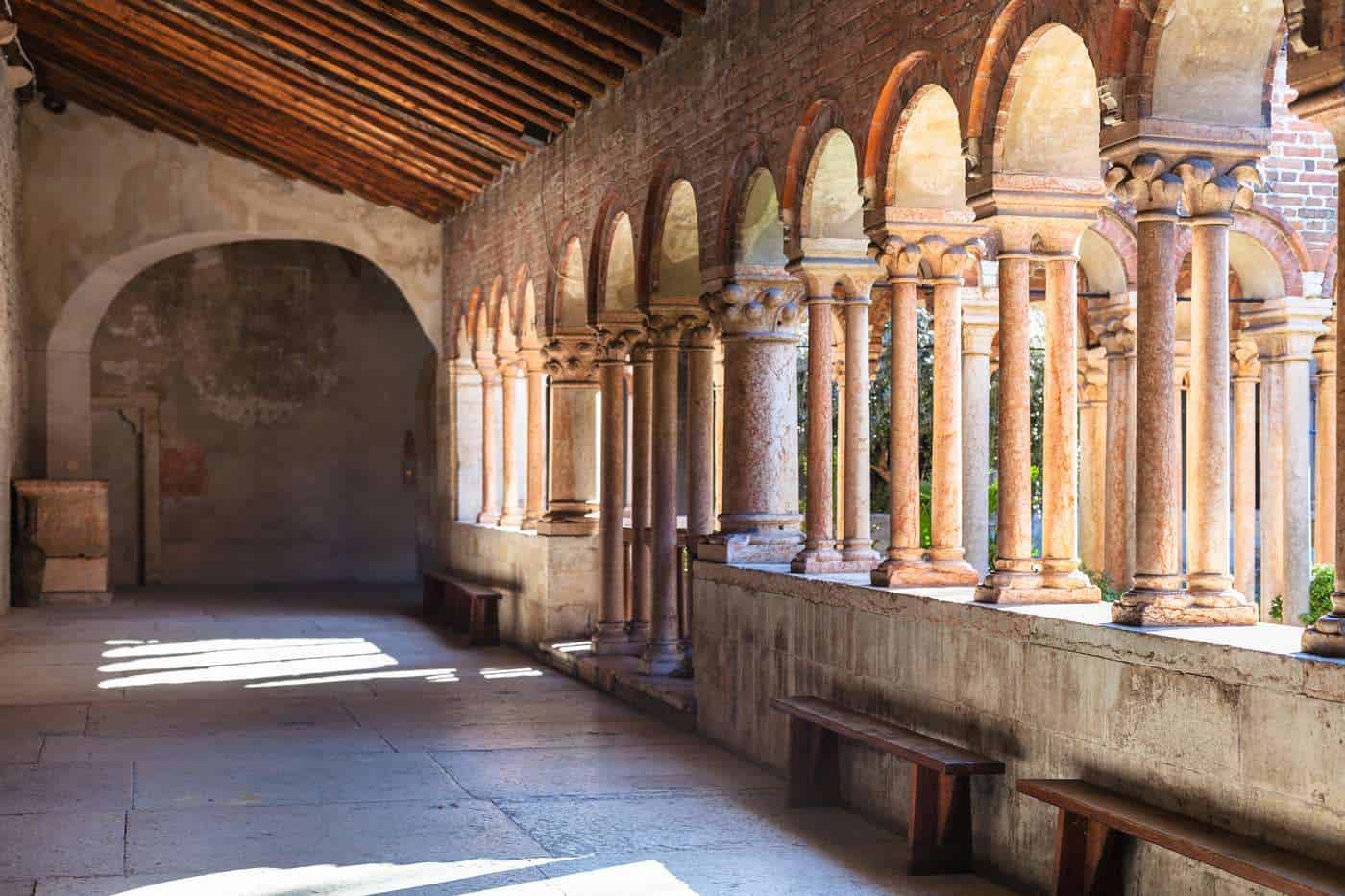 Archivo arquitectónico con columnas y arcos en un antiguo edificio religioso o histórico.