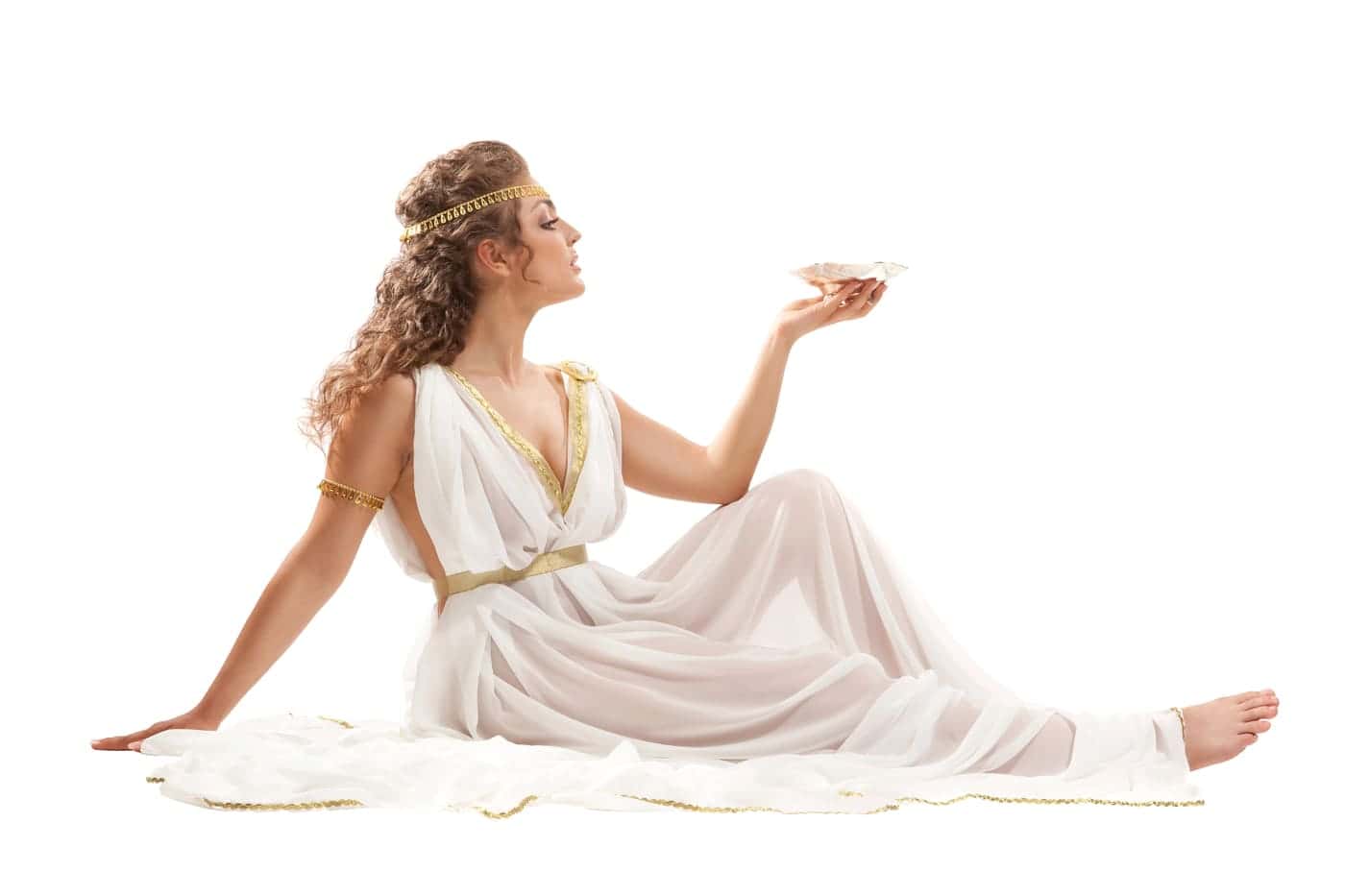 Sabia mujer vestida con toga blanca y accesorios dorados, sosteniendo un caracol en la mano.