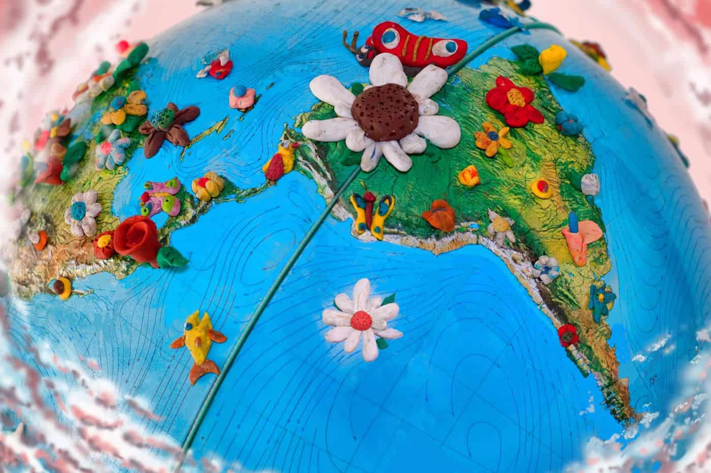 Tierra con detalles de plastilina que representan diferentes regiones y elementos naturales y culturales.