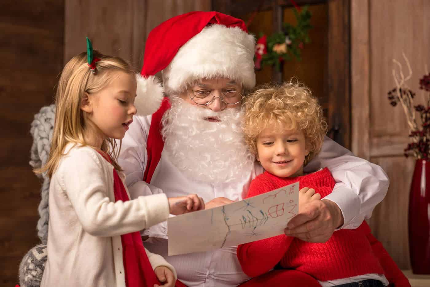 Papá Noel leyendo una carta a niños durante la Navidad.