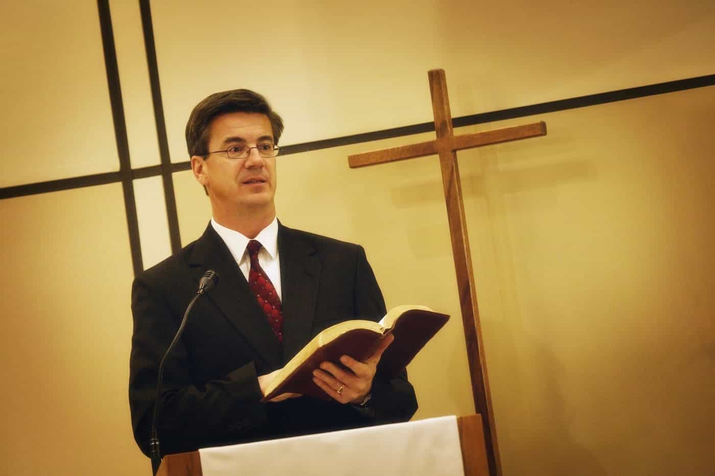 Filosofia en la red, plataforma de divulgación filosófica, enseñanza y reflexión religiosa, imagen de un hombre leyendo en un púlpito con cruz de fondo.