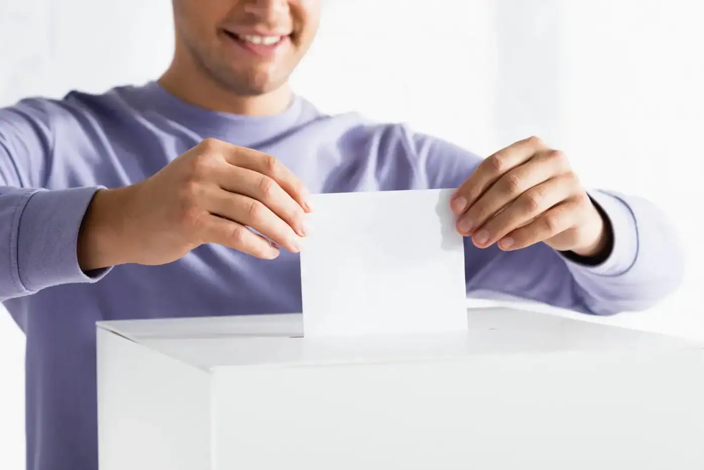 Votante depositando su boleta en una urna electoral.