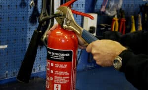 man servicing fire extinguisher in the workshop