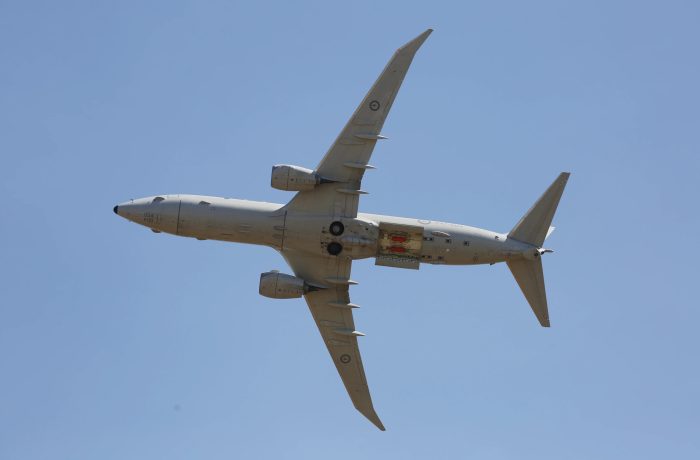 Military aircraft flying in clear blue sky during testing.