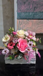 Aranjament floral pastel Pinkwood Elegance cu trandafiri, orhidee cymbidium, gerbera și crizanteme în cutie de lemn, realizat in atelierul Fleur Delire Râmnicu Vâlcea.