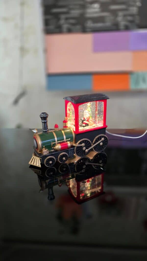 locomotivă de Crăciun cu Moș Crăciun și brad, iluminată și decorată cu fulgi de zăpadă
