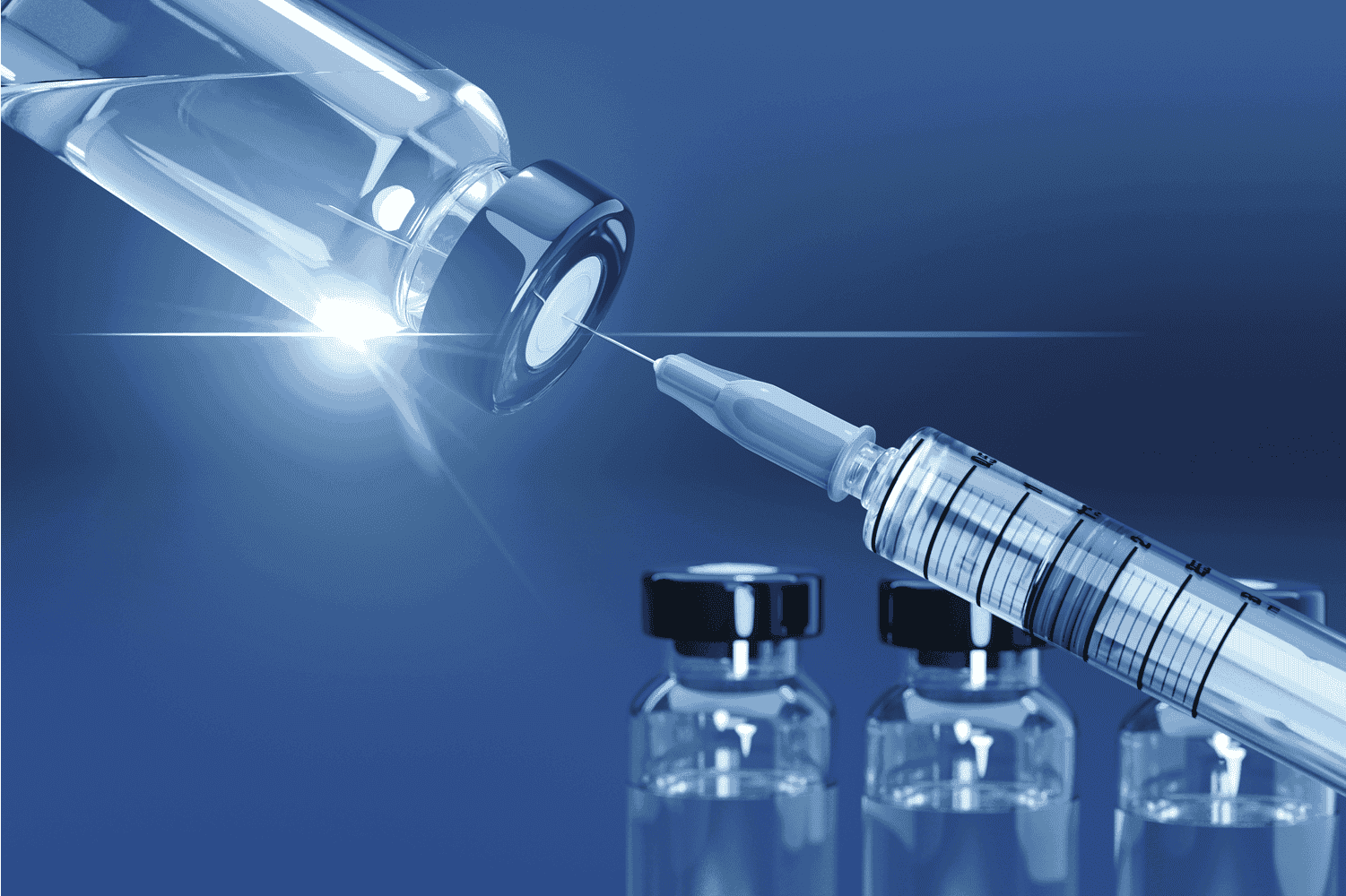 A syringe needle drawing liquid from a small medical vial, with several additional vials blurred in the background against a blue gradient backdrop.